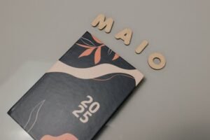 An aesthetic 2025 planner paired with wooden letters spelling 'MAIO'.